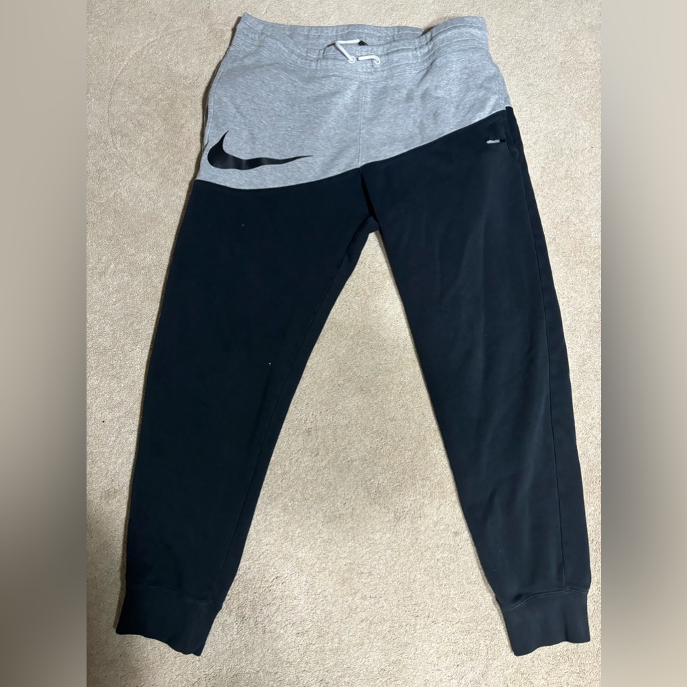 Nike black and grey sweatpants has a hole by the pocket
